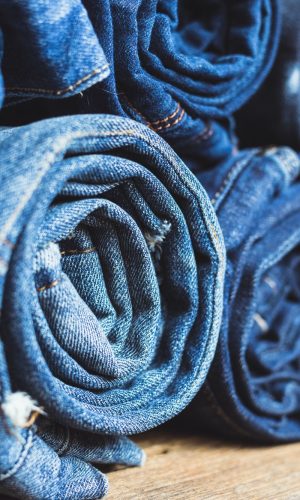Jeans stacked on a wooden background